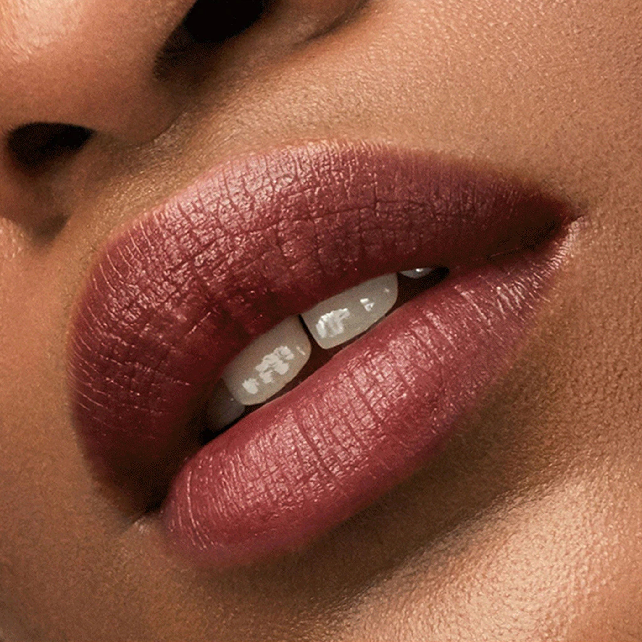 Close-up of a person's lips with a focus on a dark pink lipstick.