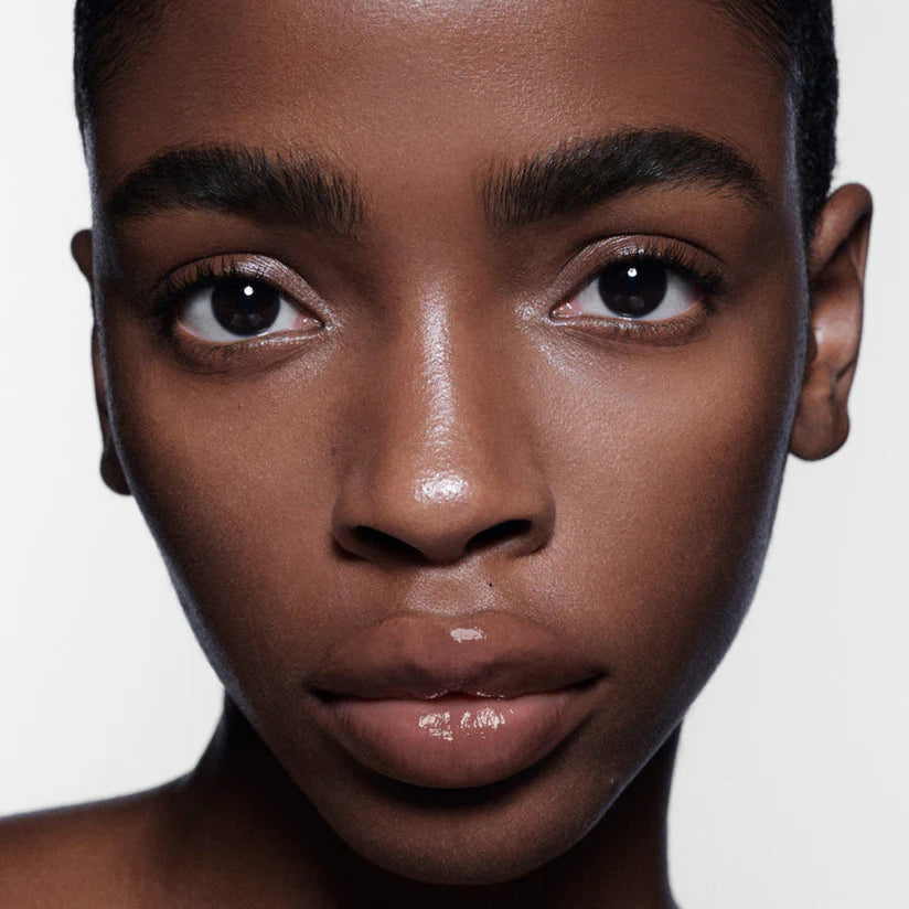 Close up image of model wearing shiny, clear lip balm