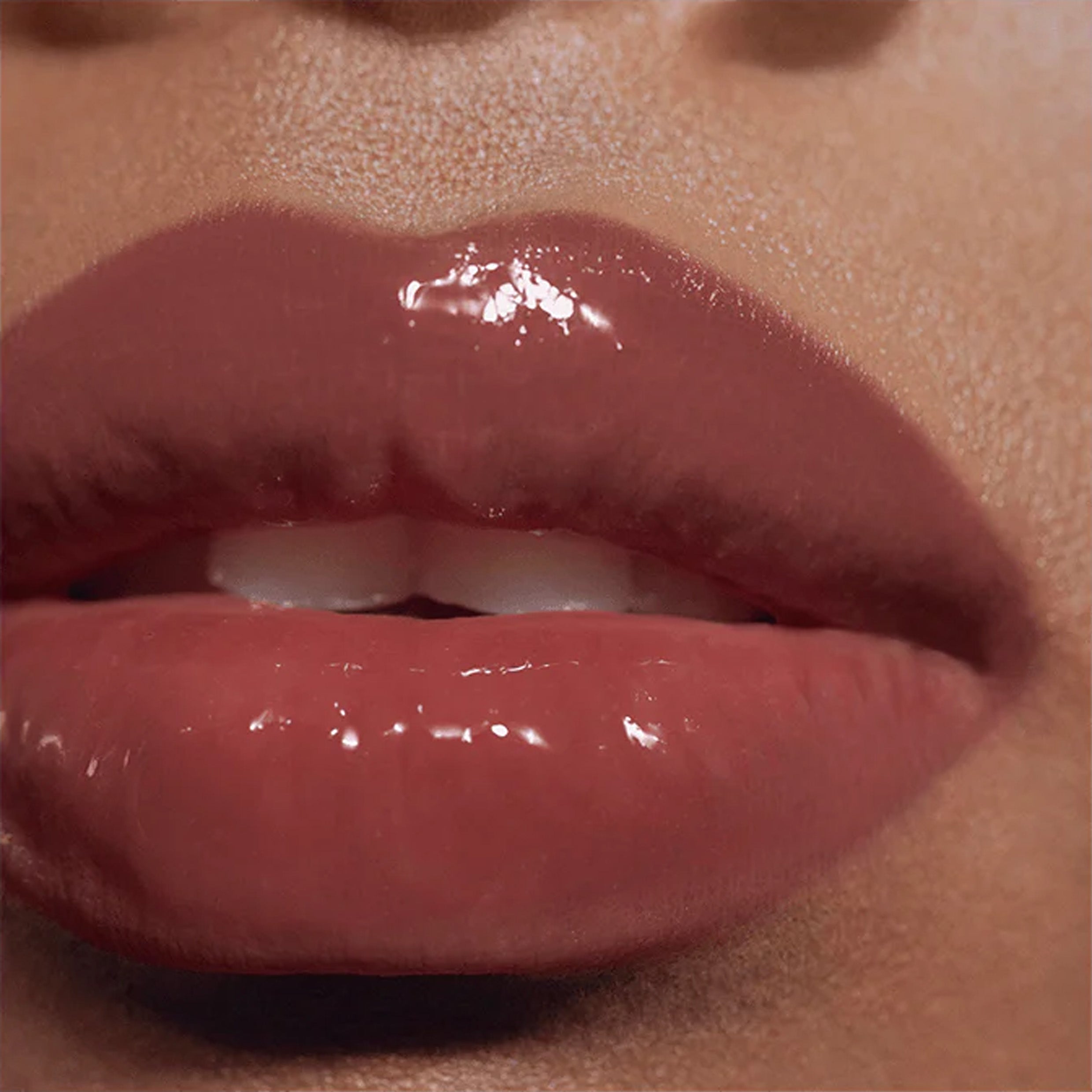 A close up omage of lips wearing shiny lip gloss