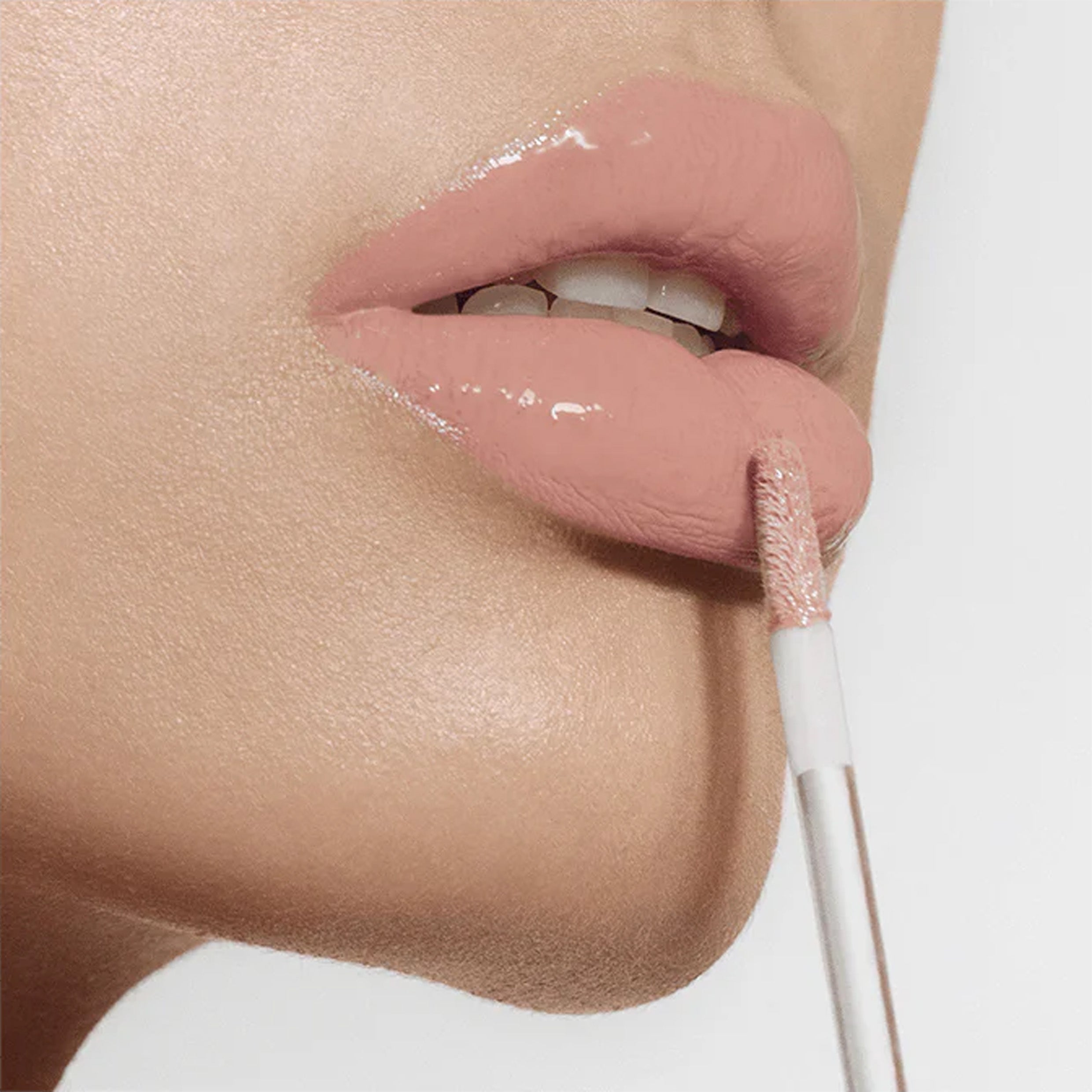 A close up image of lips wearing a pink lipgloss