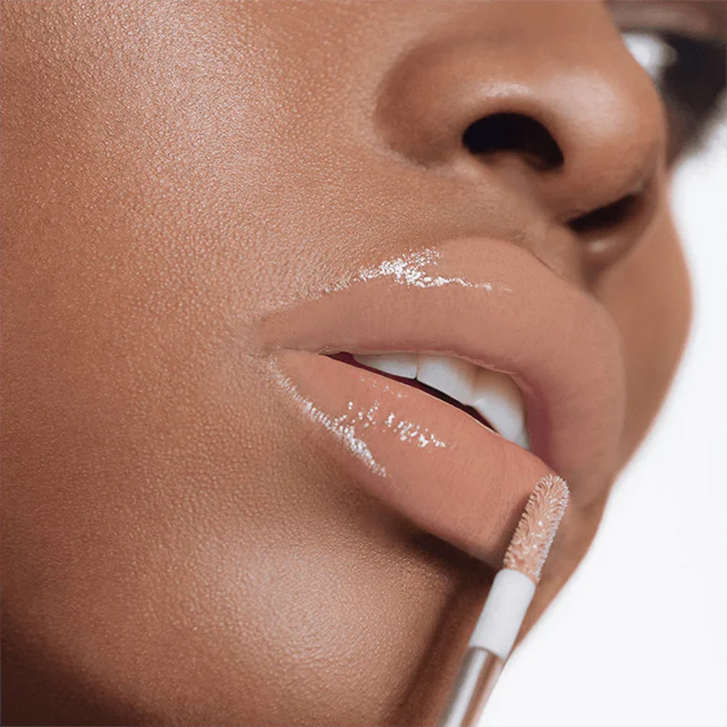 A close up image of model wearing lipgloss