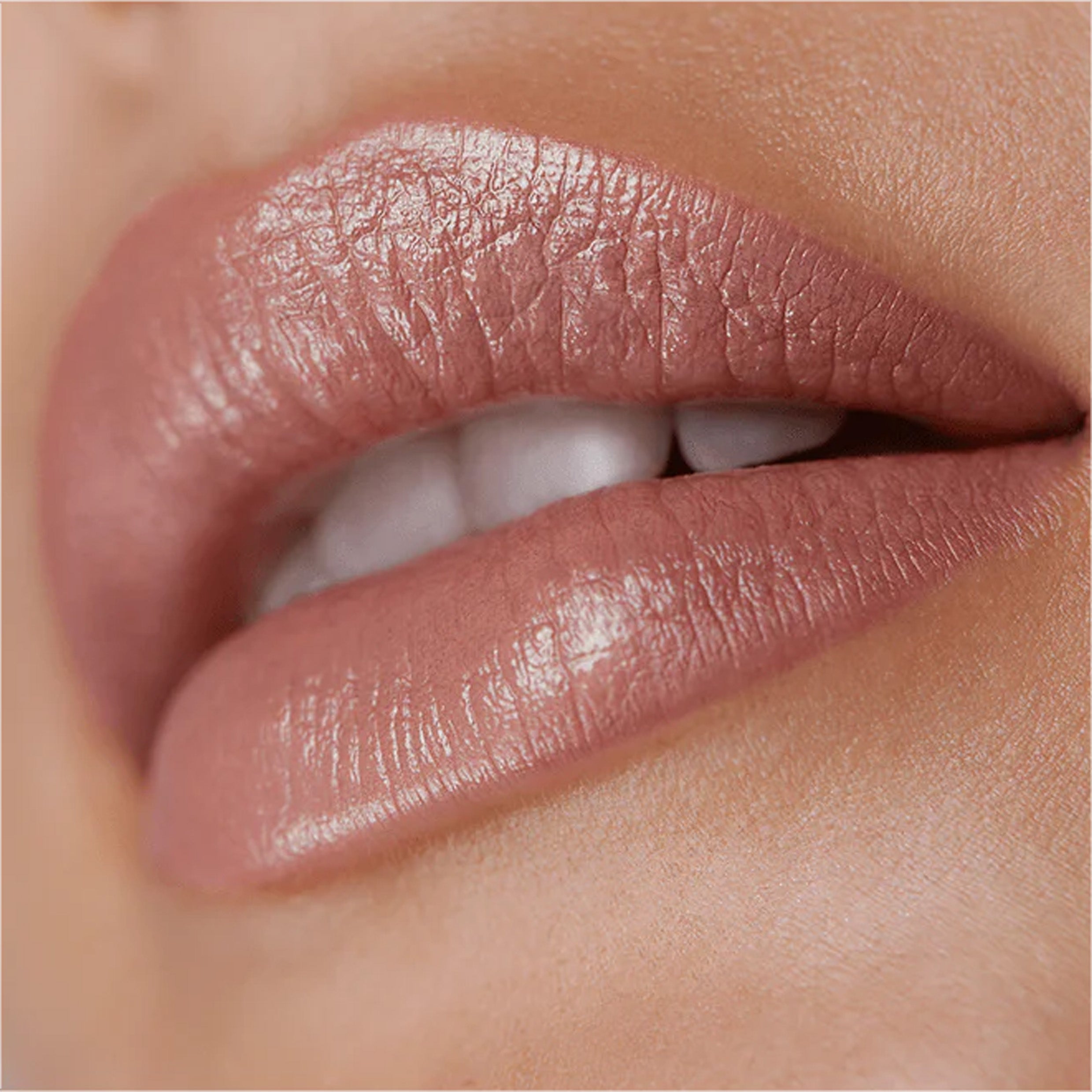 A close up image of lips wearing a pale nude lipstick