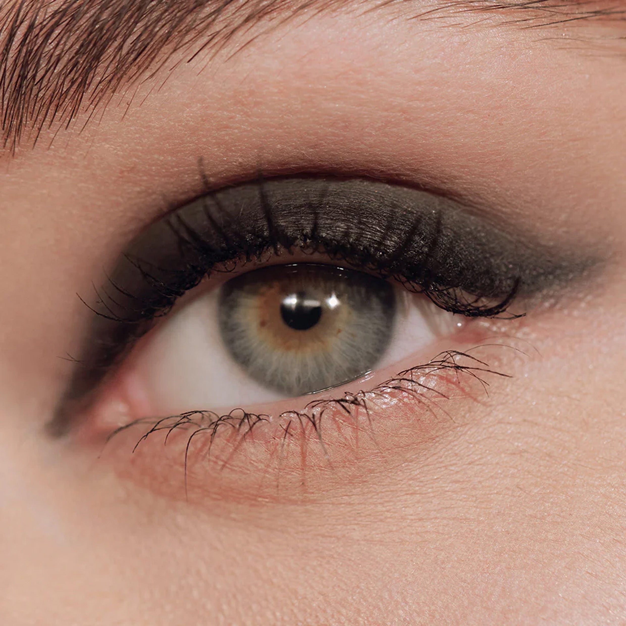 A close up image of an eye with black eyeliner applied to the eyelid.