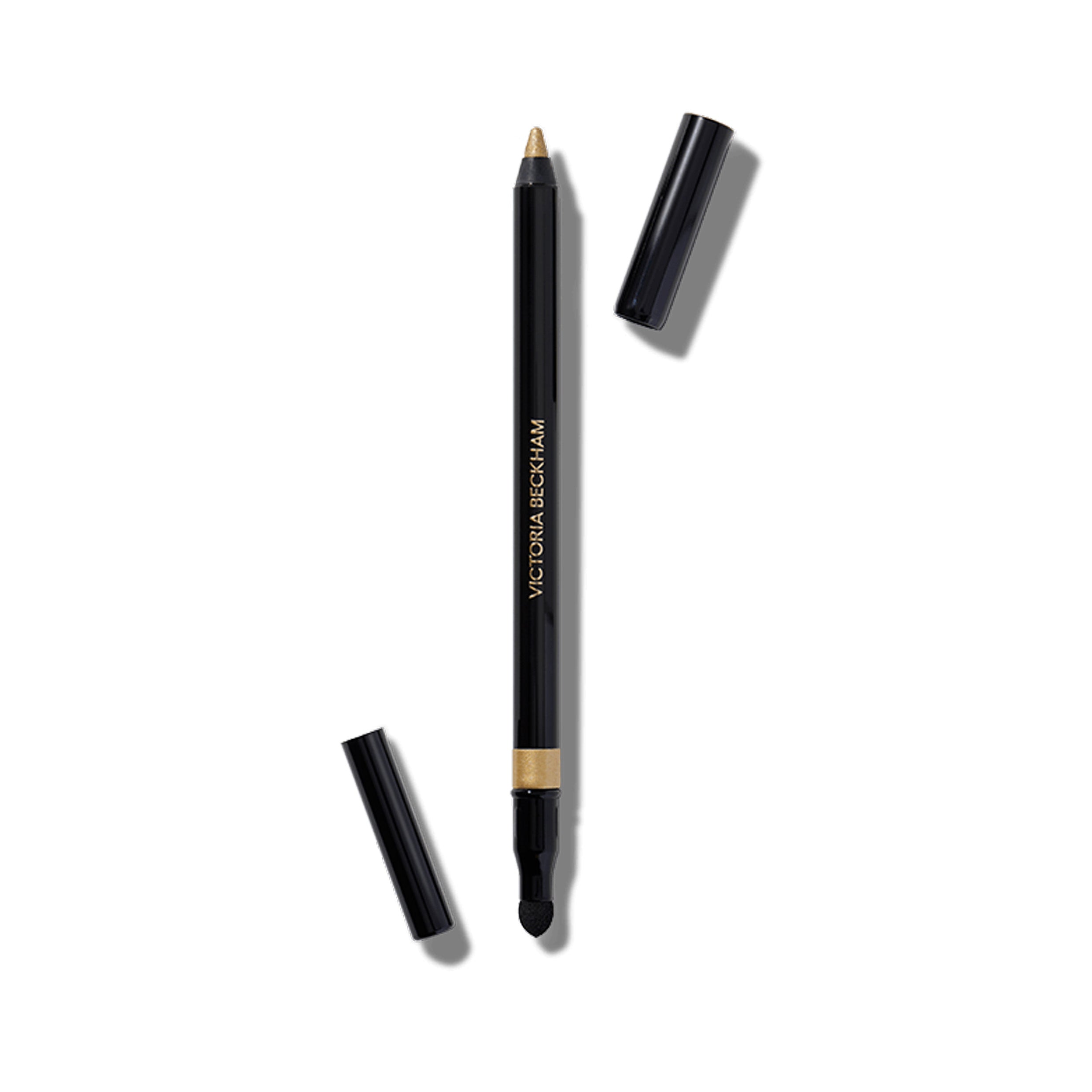 A gold-colored eyeliner pencil capless, showing the actual gold lead tip, with the brand name 'Victoria Beckham Beauty' on the side.