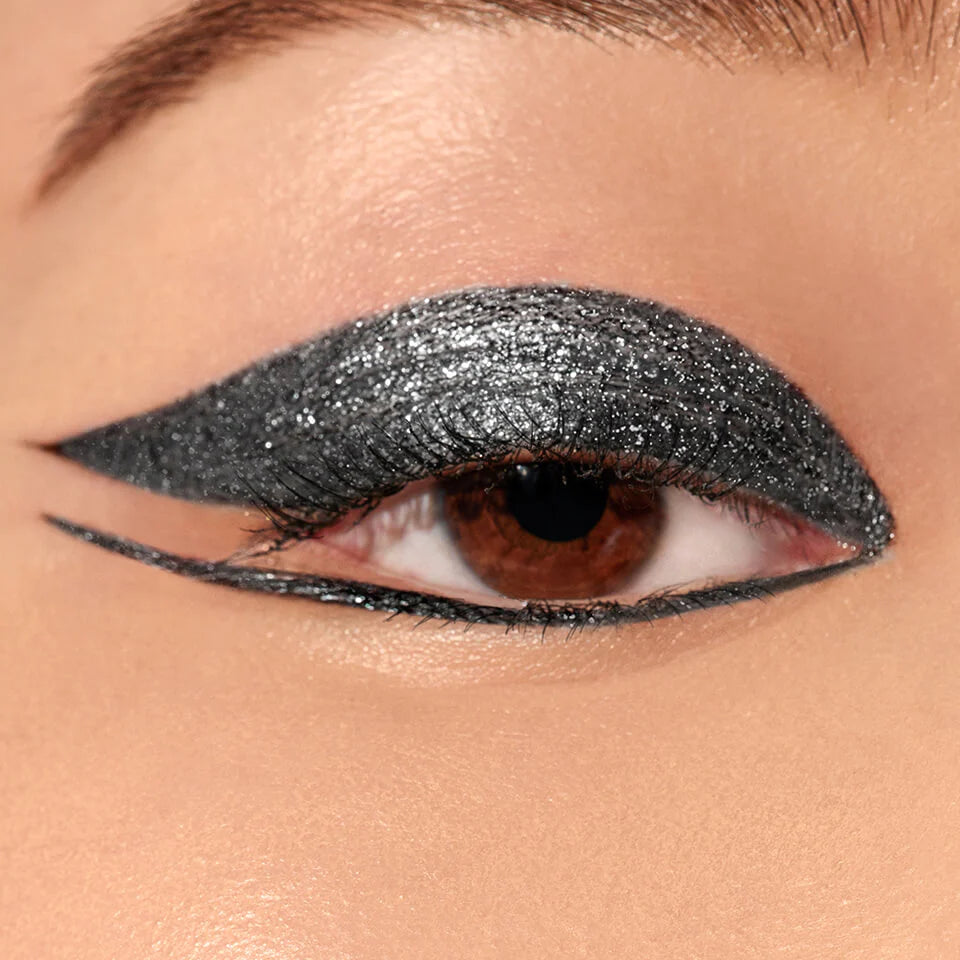 A close up image of an eye wearing Victoria Beckham Beauty Satin Kajal Jewel Liner in Night Flash.