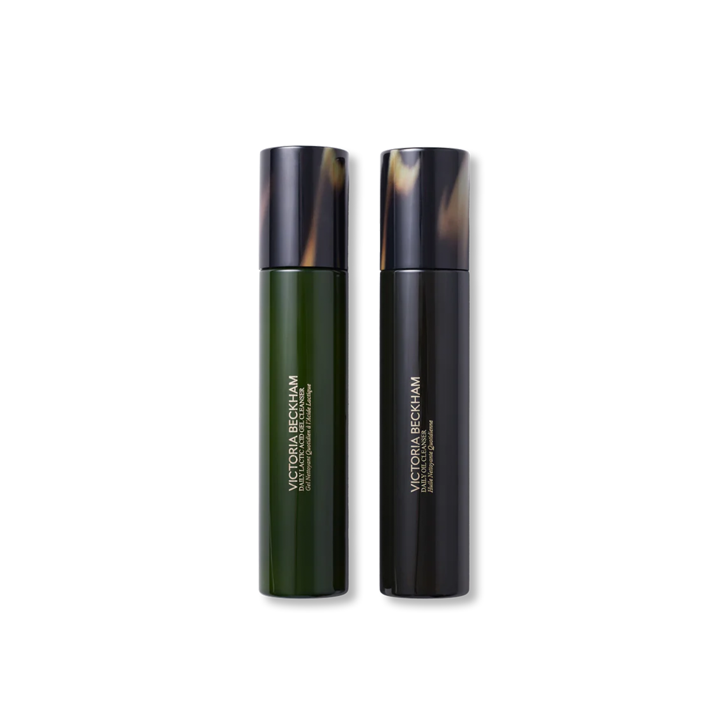 Two bottles of Victoria Beckham Beauty daily cleansing skincare products, one labeled as 'The Daily Oil Cleanser' and the other as 'The Daily Lactic Acid Gel Cleanser'.