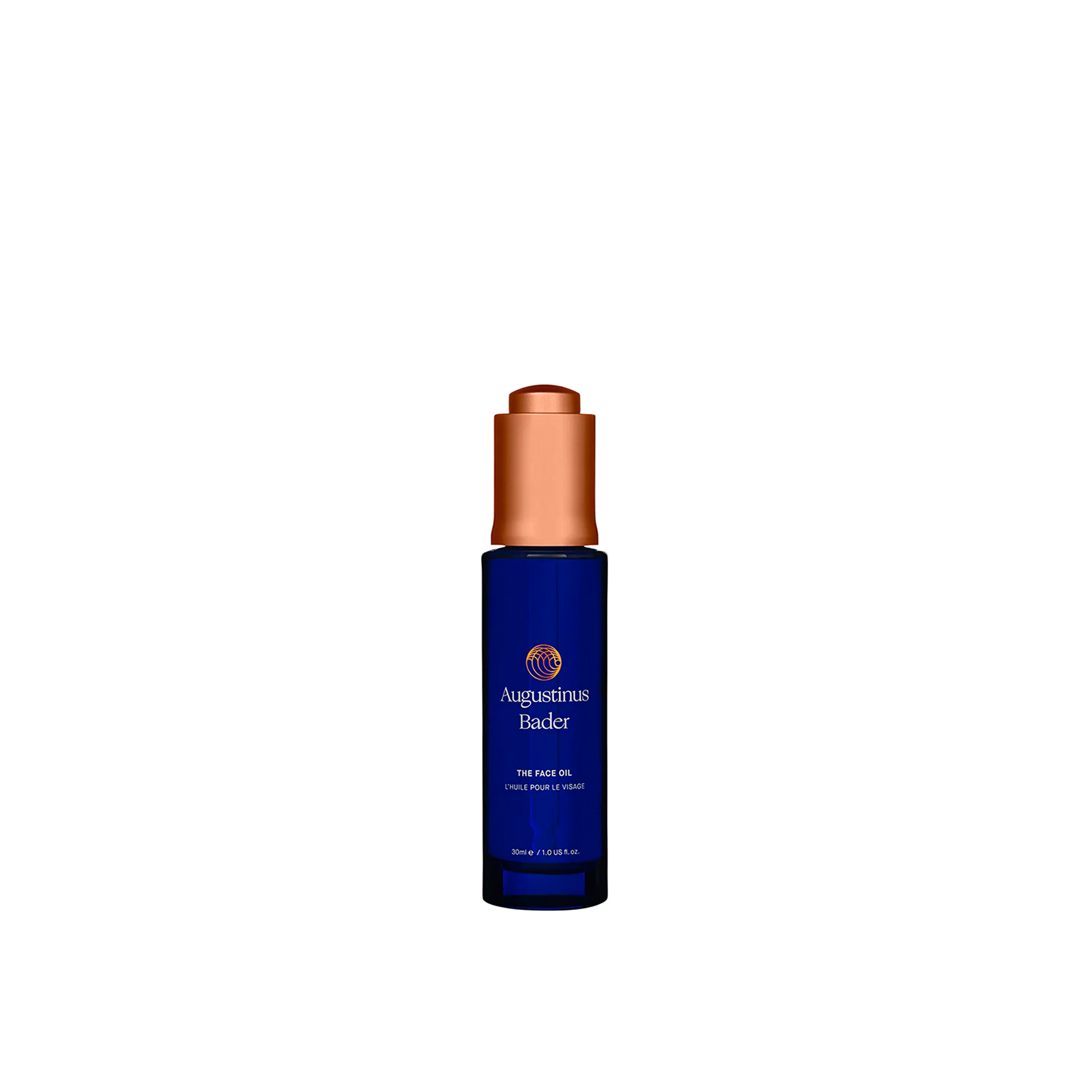A bottle of Augustinus Bader The Face Oil with a dark blue label and copper-colored cap.