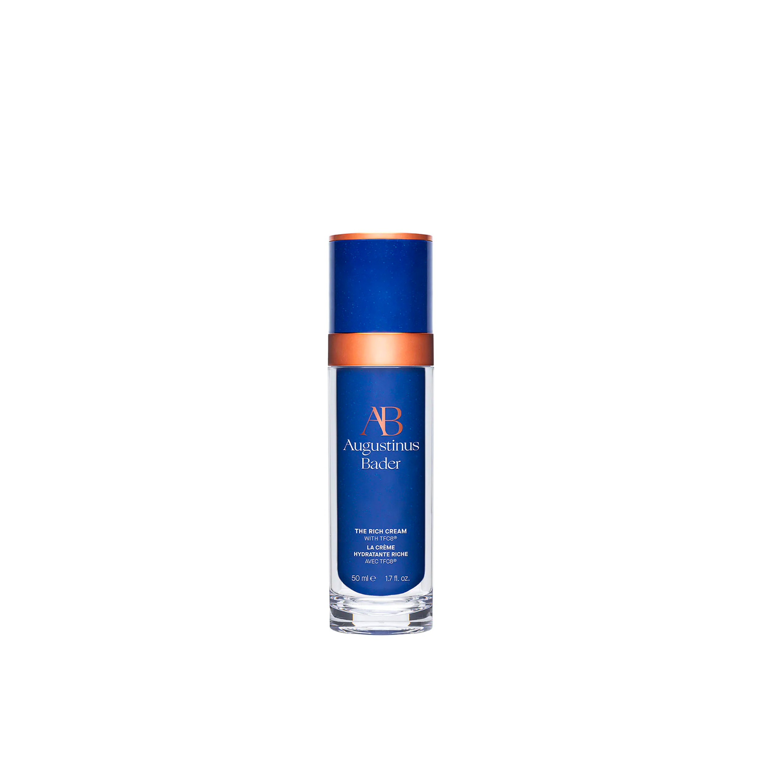 A blue and white bottle of Augustinus Bader The Rich Cream with a copper-colored cap.