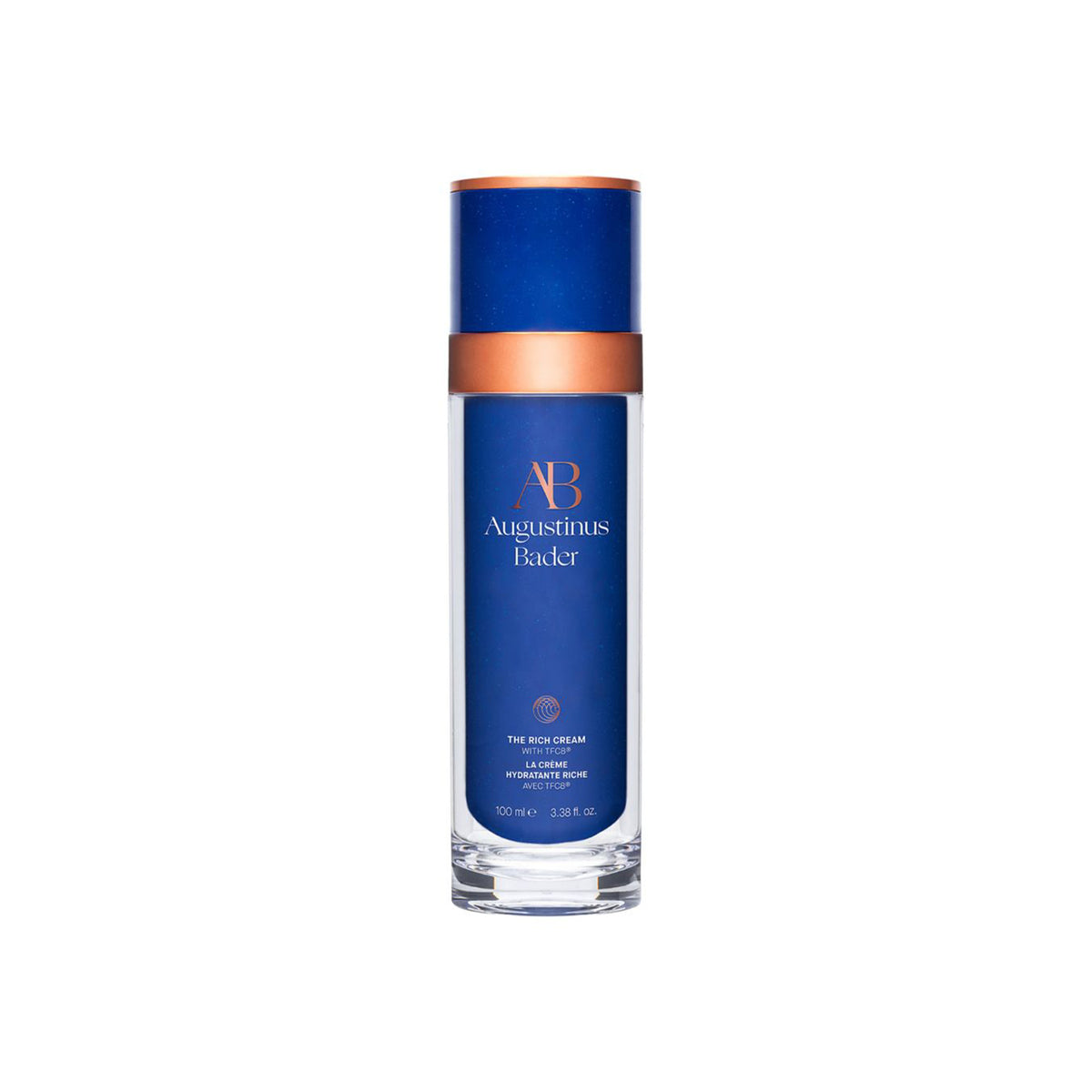 A blue and white bottle of Augustinus Bader The Rich Cream with a copper-colored cap.