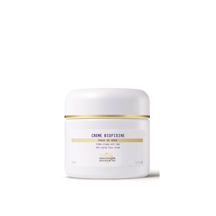 A white jar of Biologique Recherche Crème Biofixine with black and gold text, indicating it is a firming cream designed for the face.