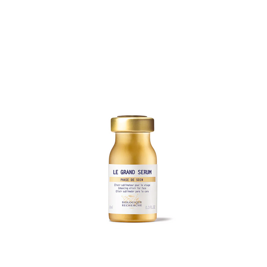 A golden glass vial of Biologique Recherche Le Grand Serum with a white label.