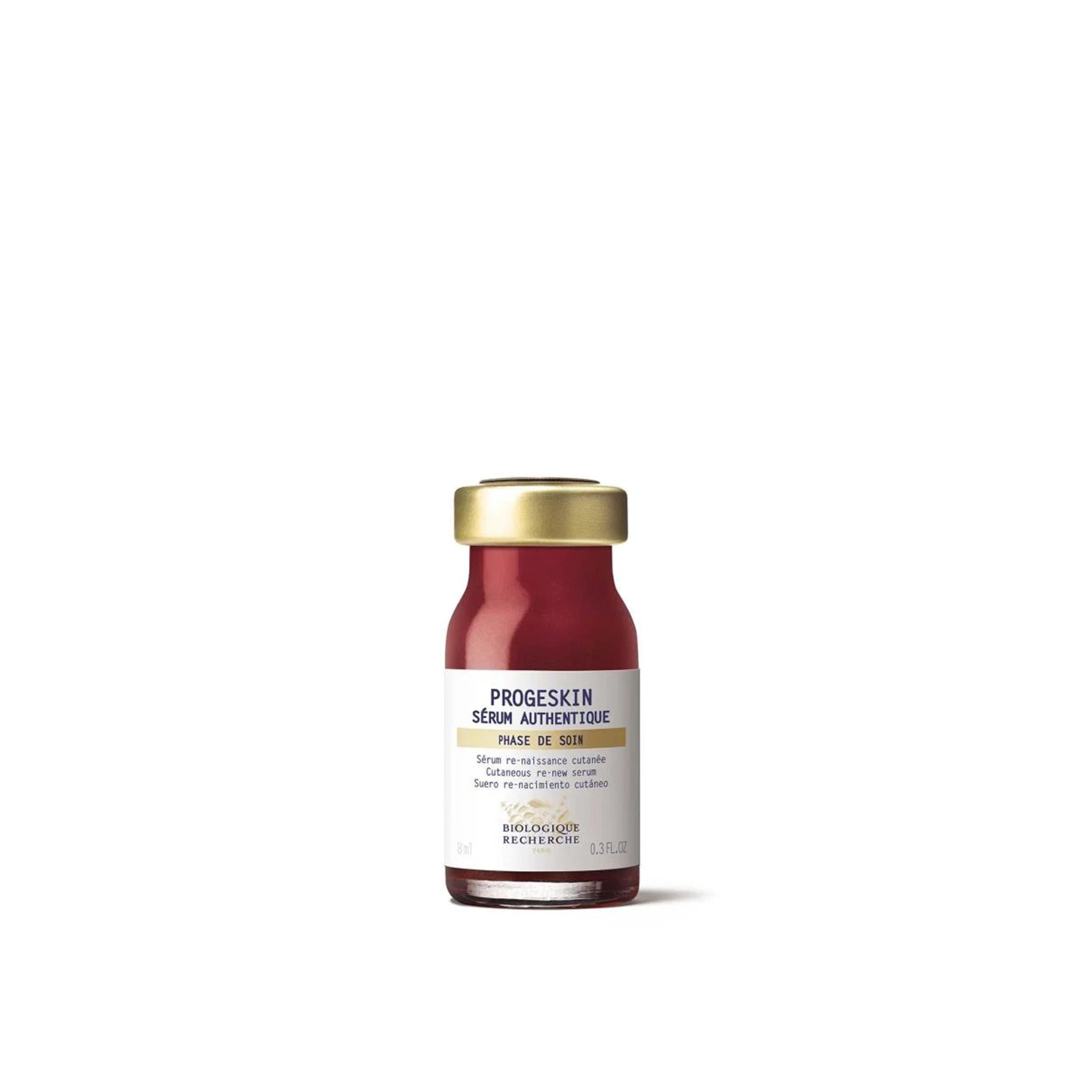 A red glass vial with a gold cap labeled 'PROGESKIN SÉRÈUM AUTHENTIQUE' which contains the Biologique Recherche Progeskin Serum.