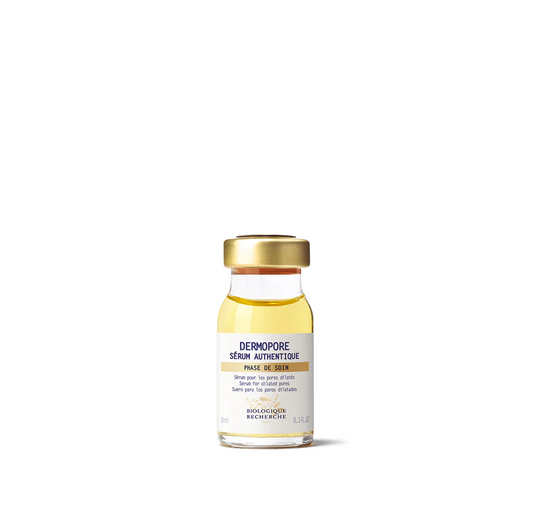 A clear glass vial with a gold cap containing yellow-colored serum, labeled 'DERMOPORE SERUM AUTHENTIQUE'.