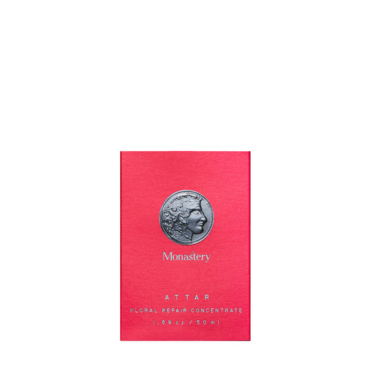 Pink packaging of Monastery Attar with a silver coin design on a white background