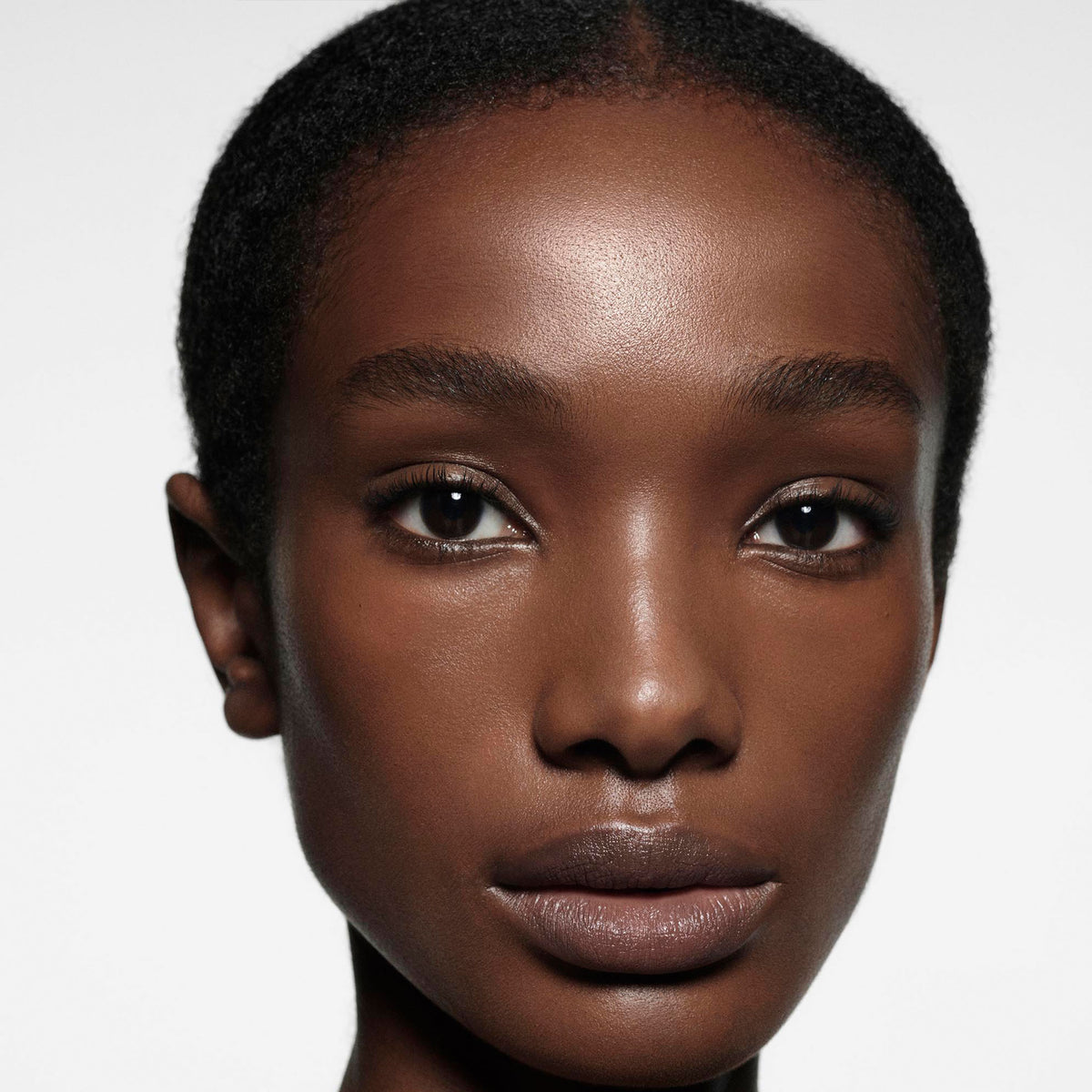 Close-up of a person with a neutral expression on a white background