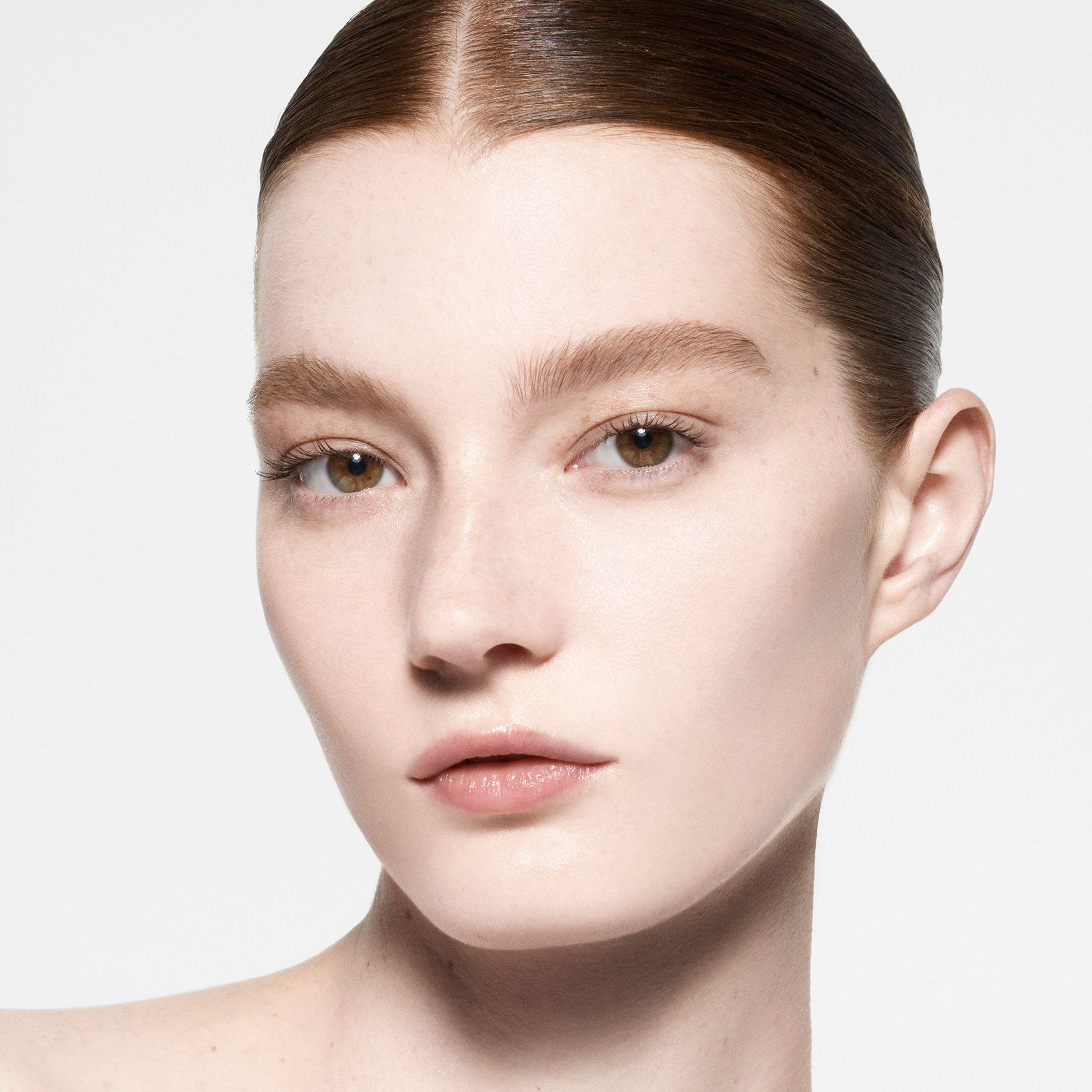 Close-up of a person with a neutral expression on a plain background