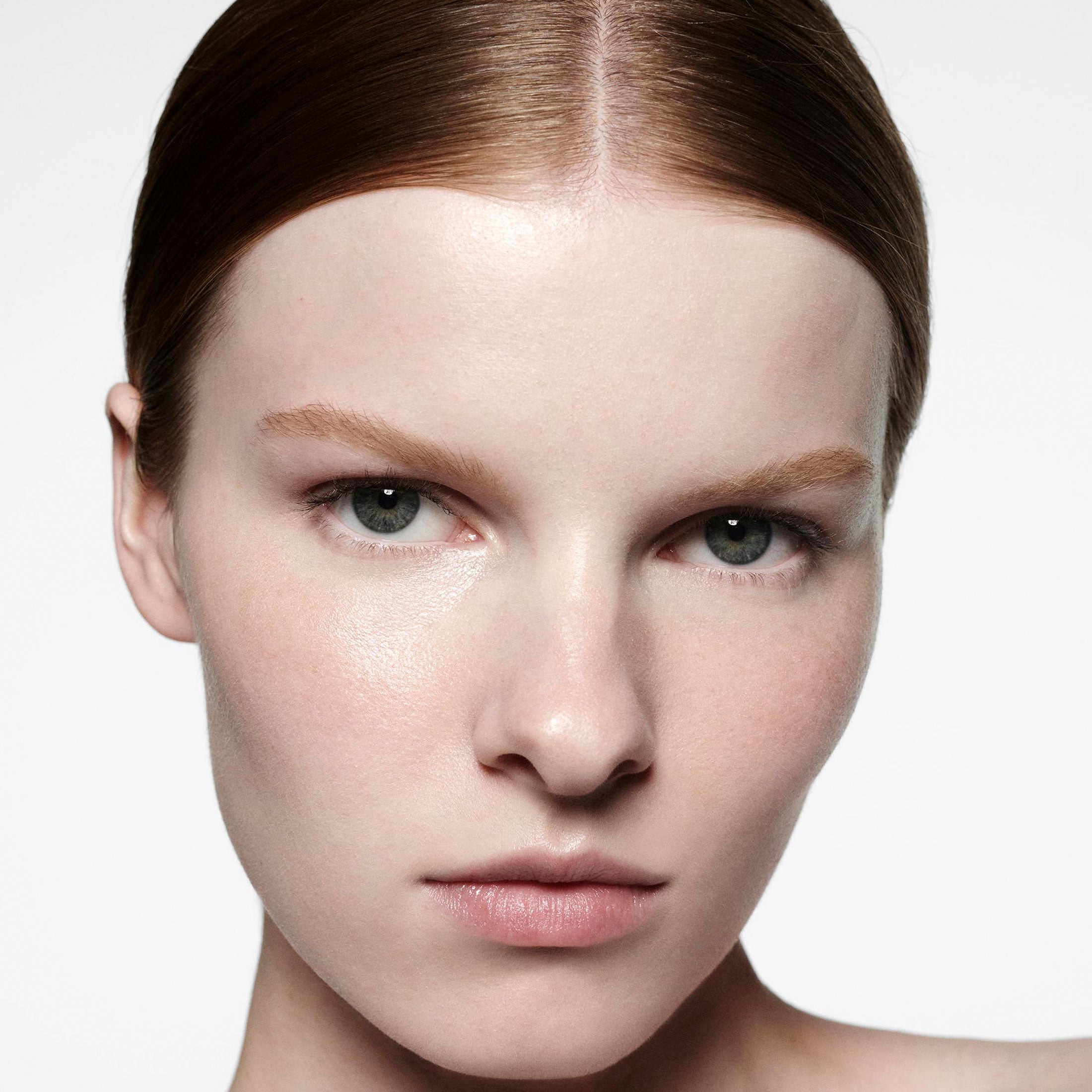 Close-up of a person with neutral makeup on a white background
