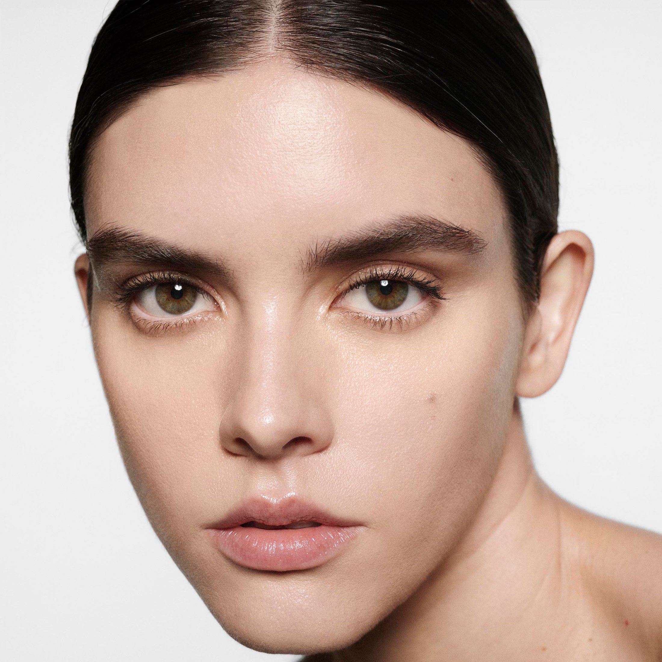 Close-up of a person with a neutral expression on a plain background