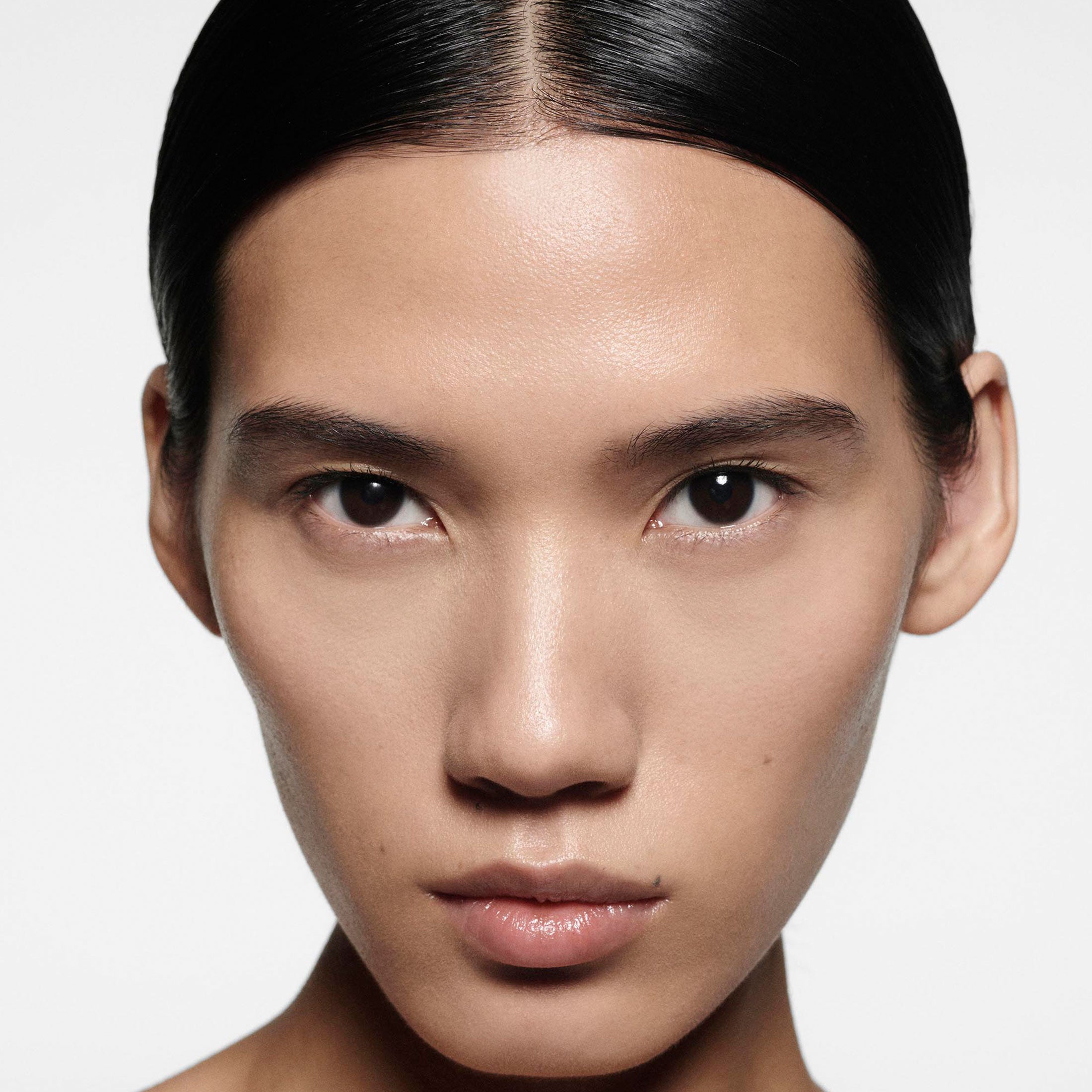Close-up of a person with a neutral expression on a plain background