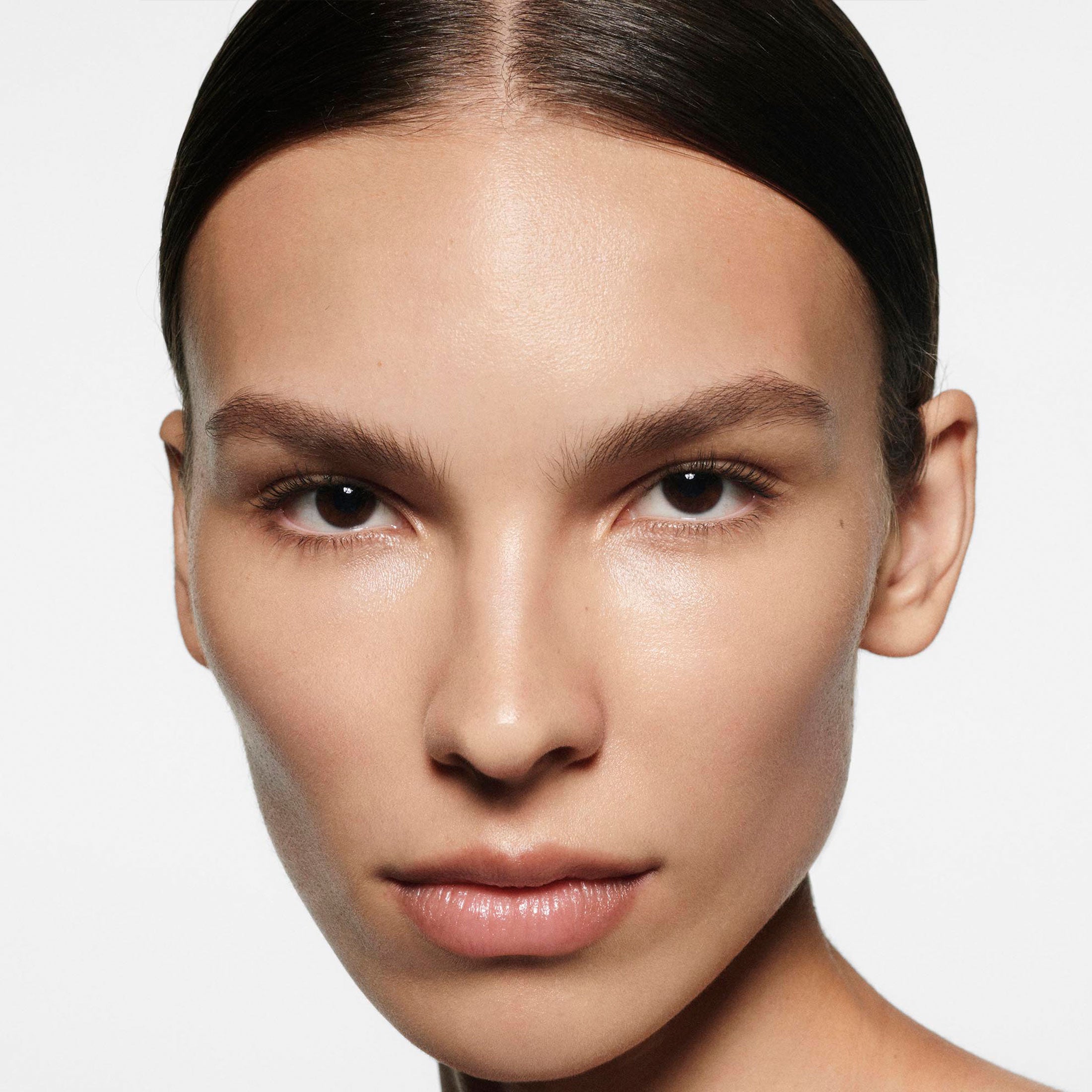 Close-up of a person with a neutral expression on a plain background