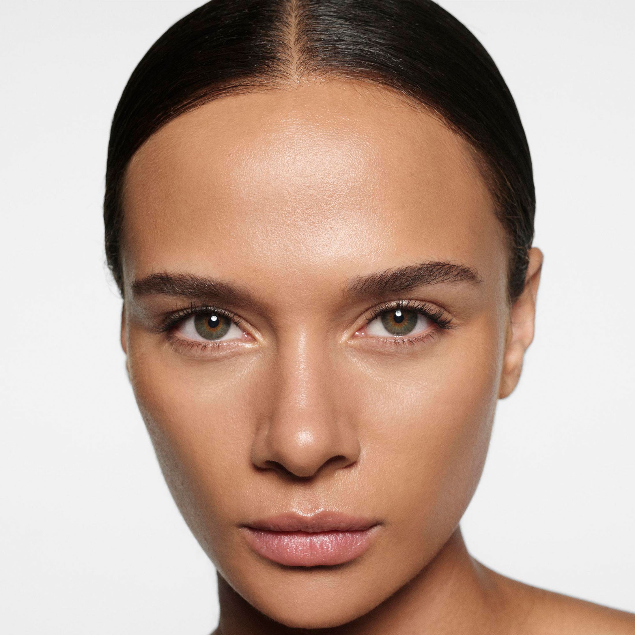 Close-up of a person with a neutral expression on a plain background