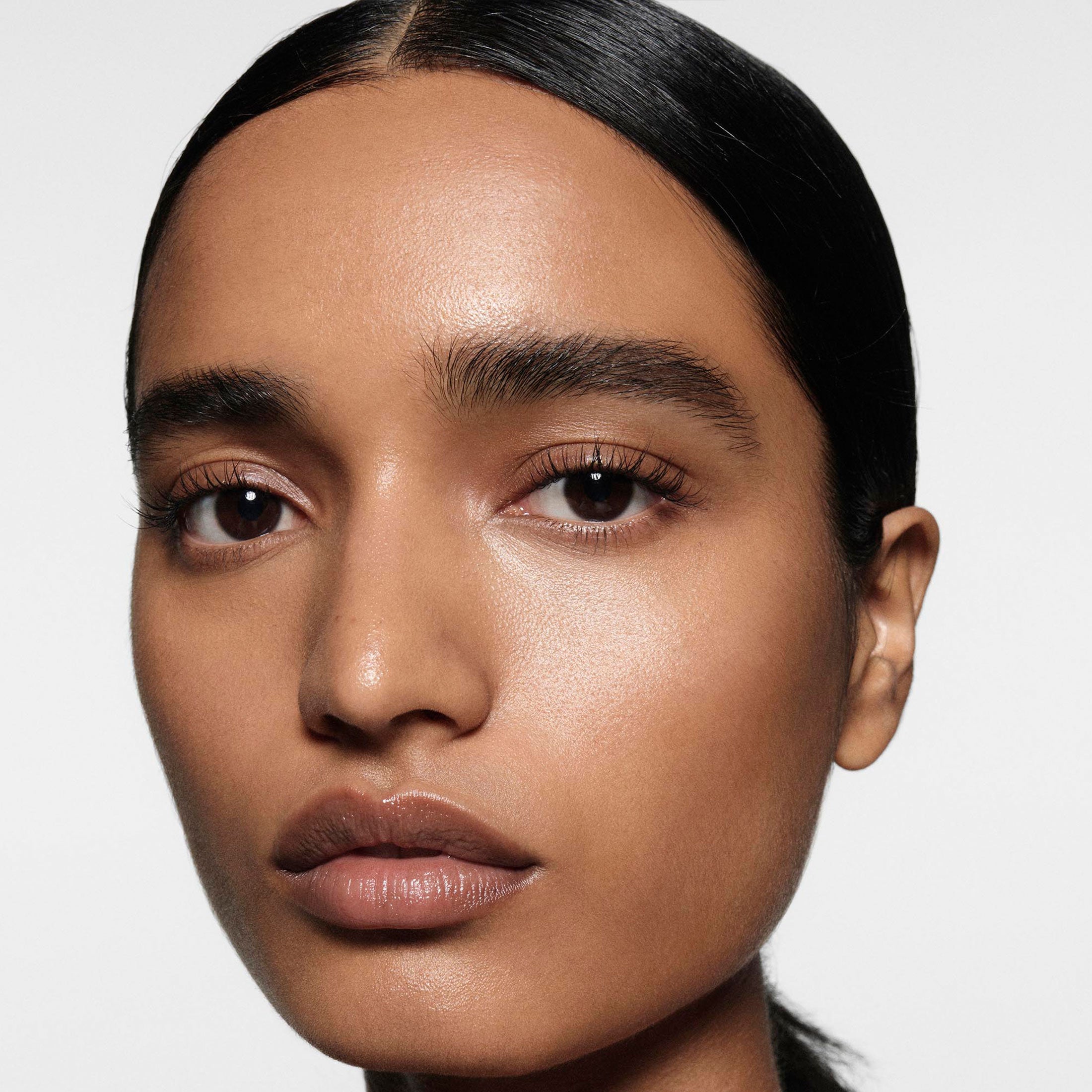 Close-up of a person with a neutral expression on a plain background