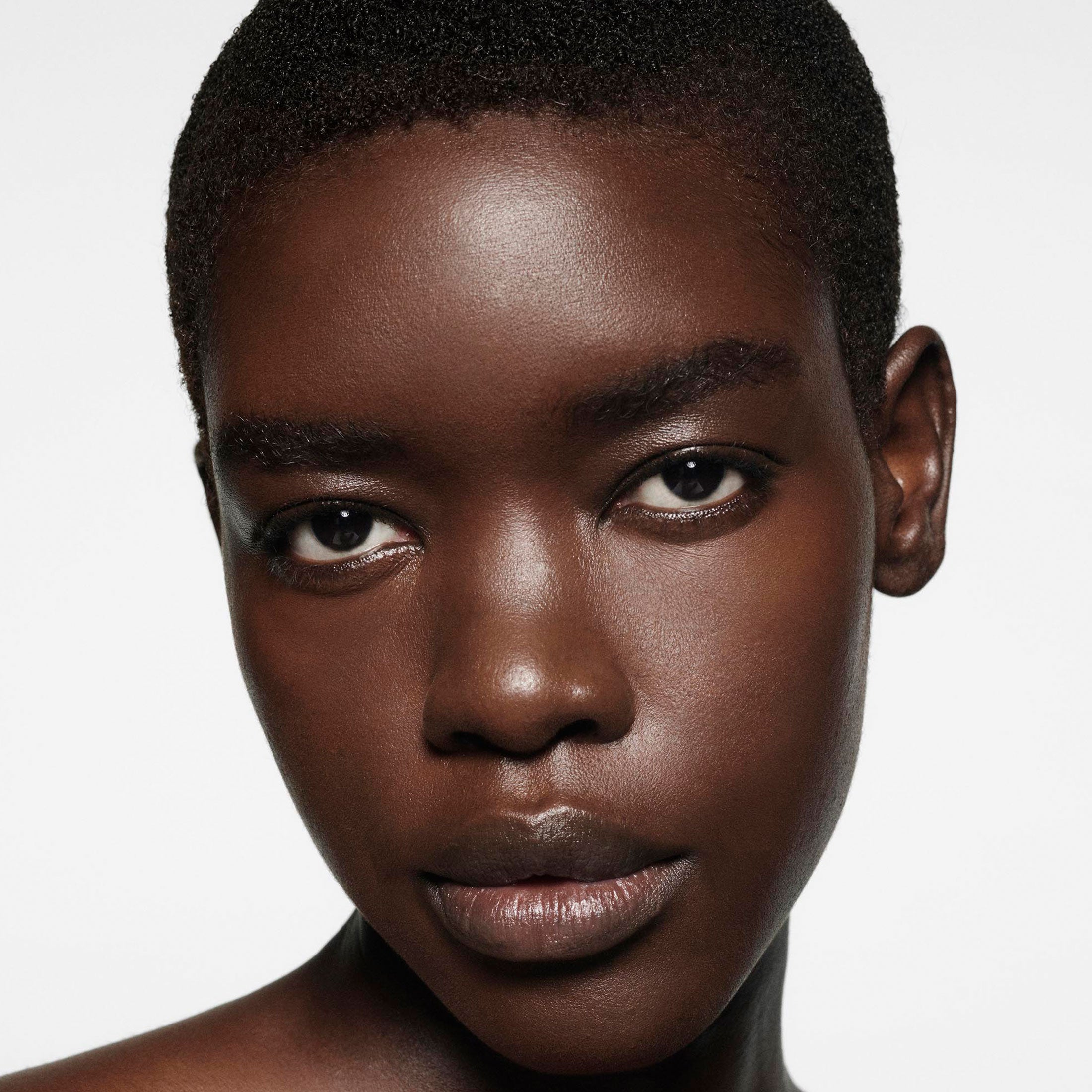 Close-up of a person with a neutral expression on a plain background
