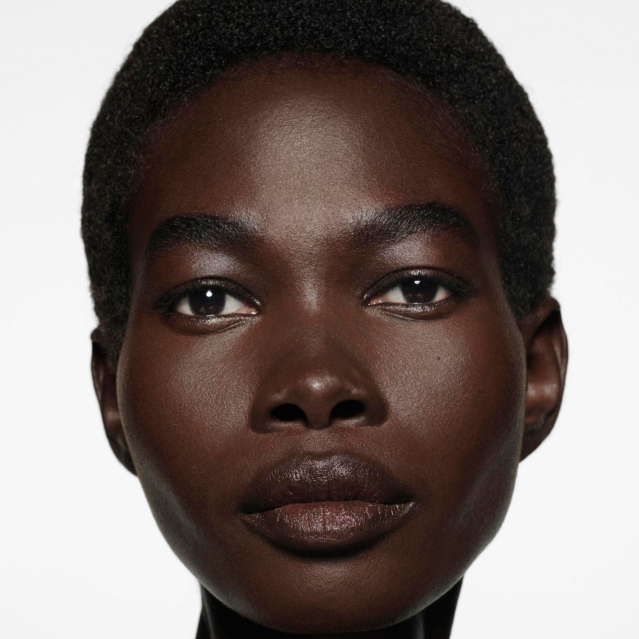 Close-up of a person with a neutral expression on a white background