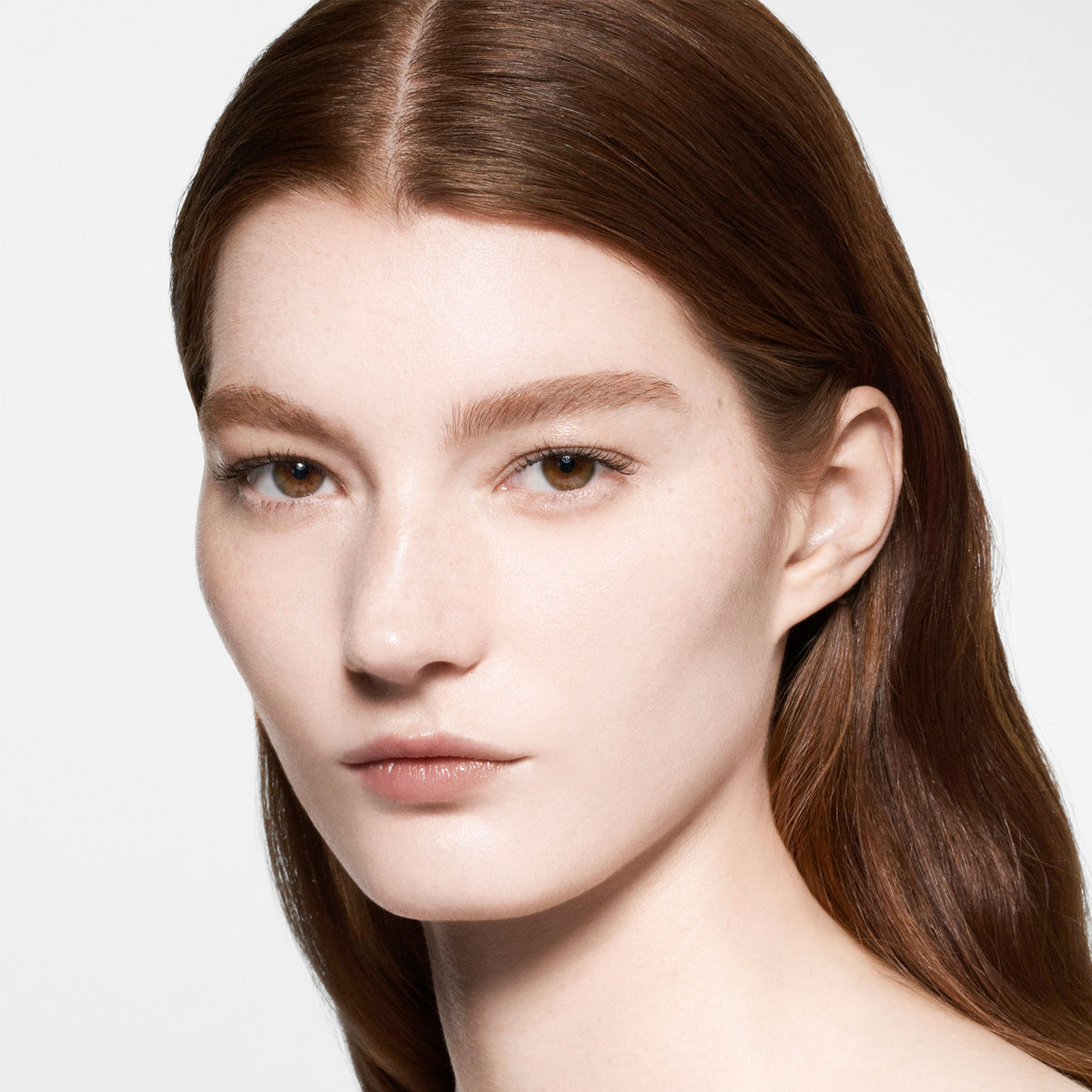 Close-up of a person with long brown hair on a plain background