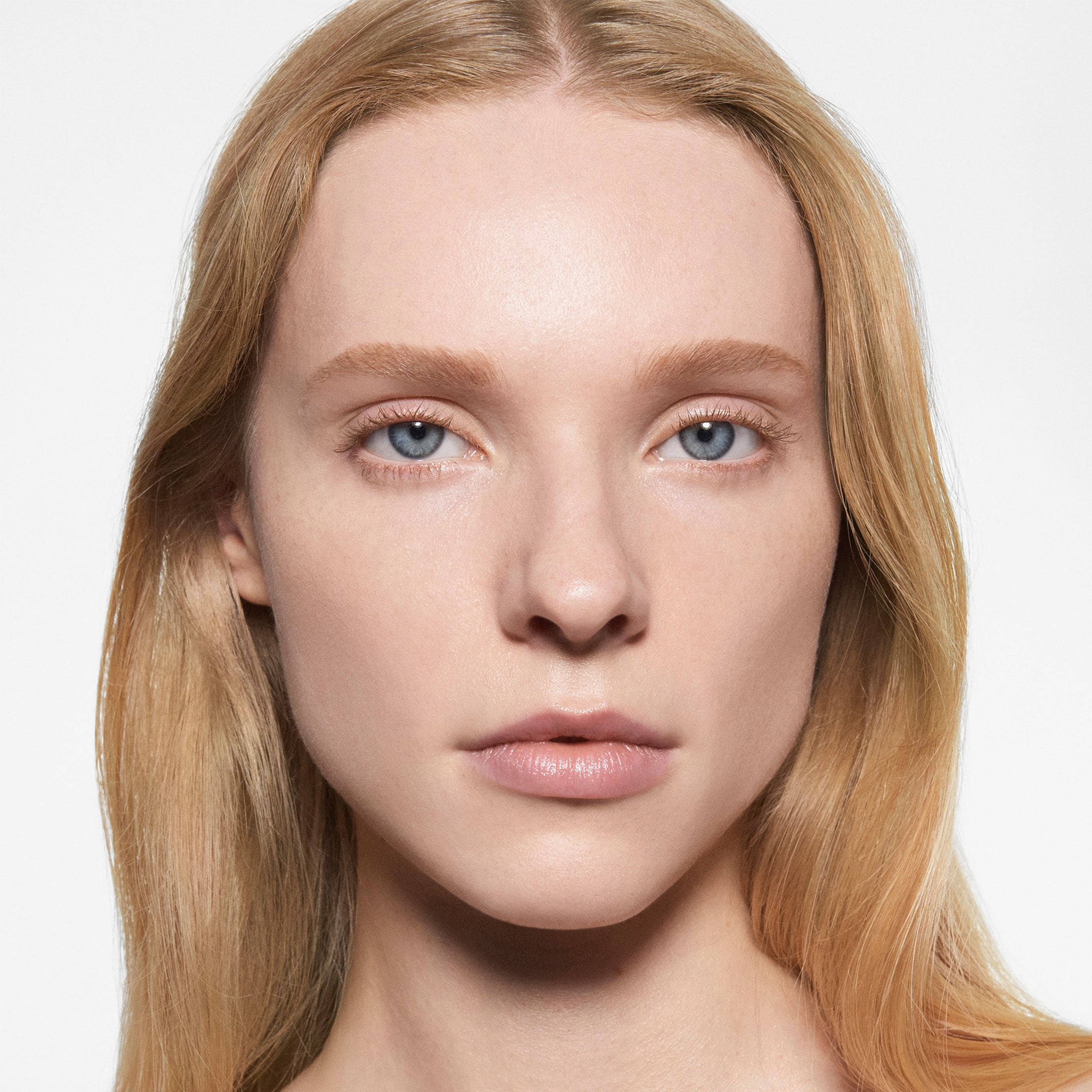 Close-up of a person with blonde hair and blue eyes on a white background