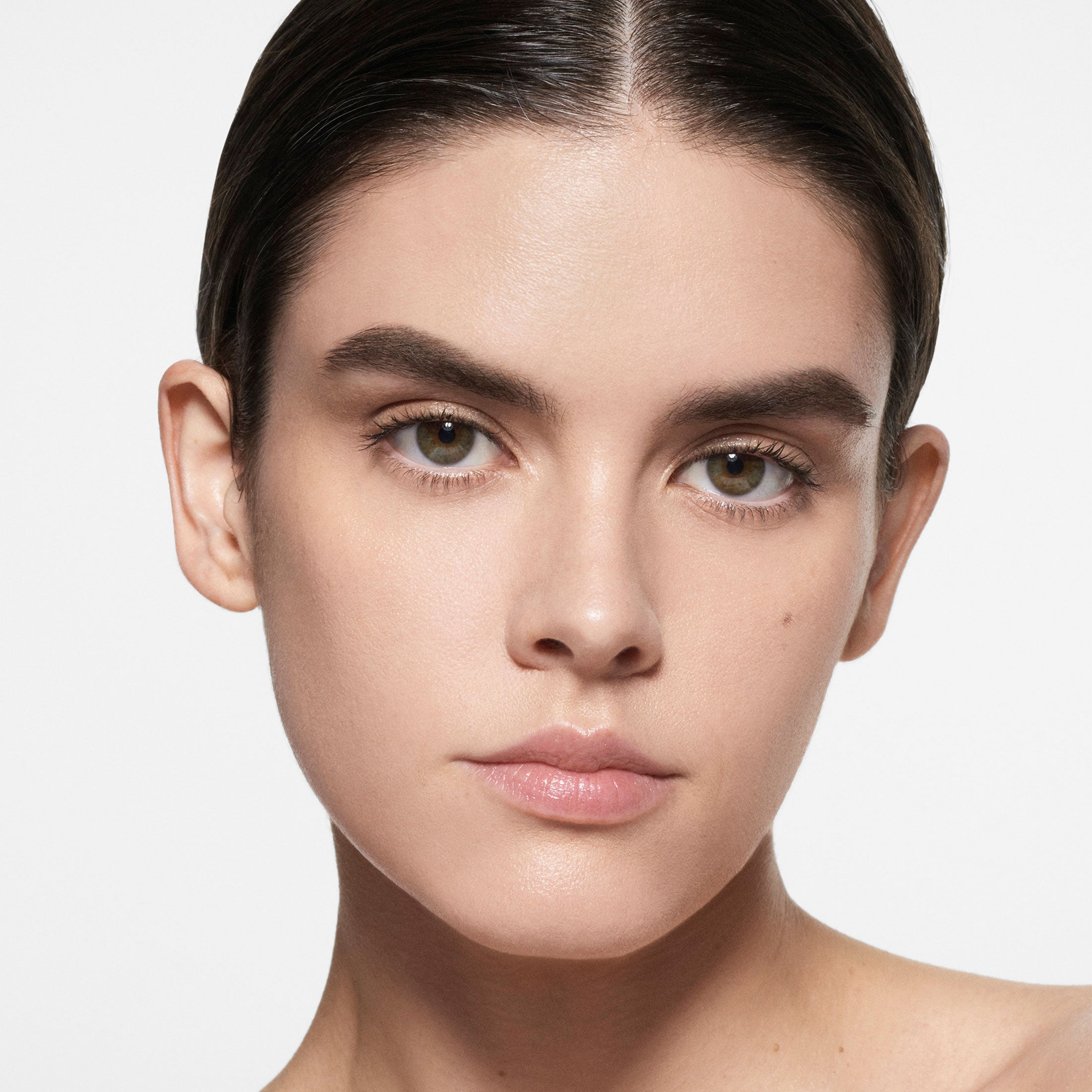 Close-up of a person's face with a neutral expression on a light background