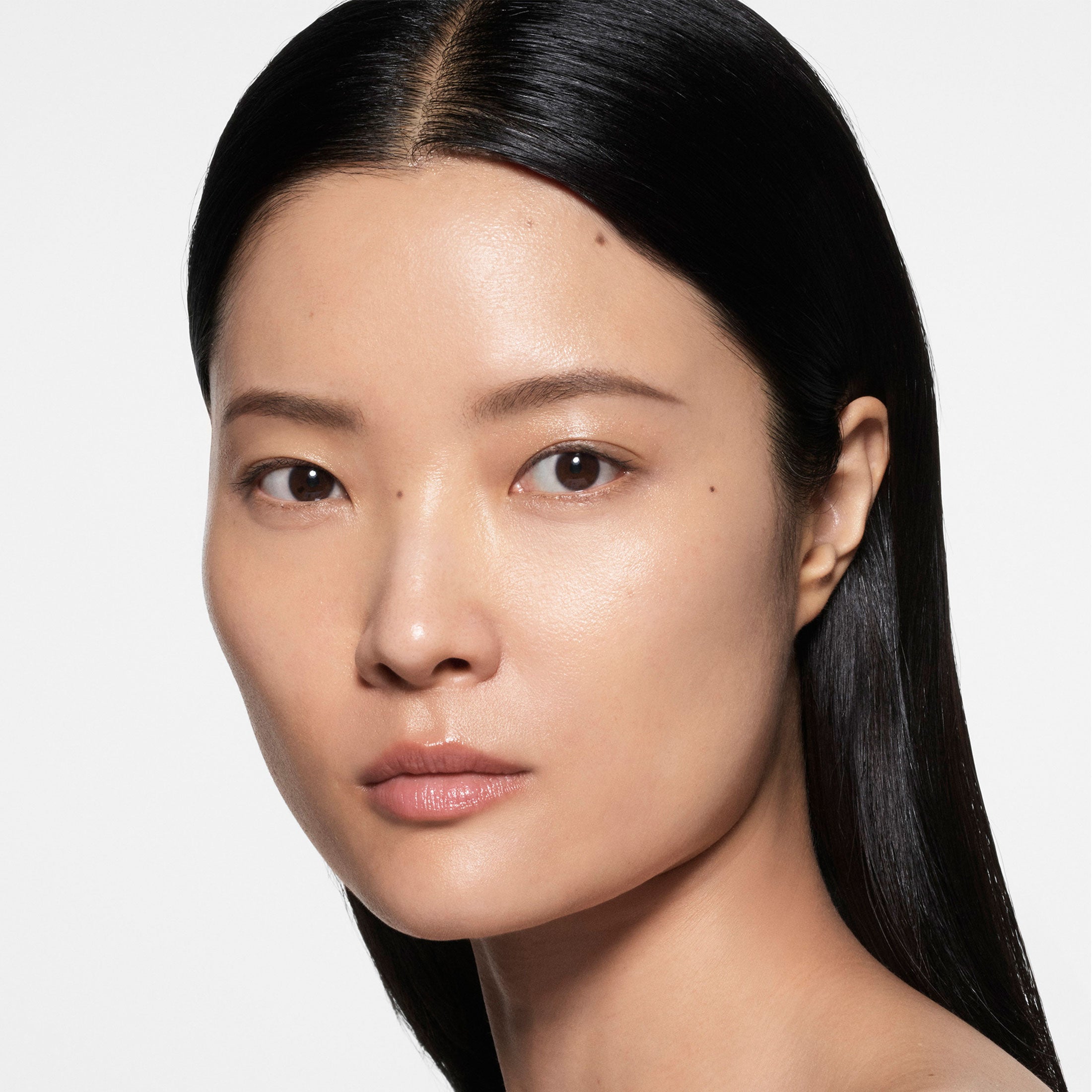 Close-up of a person with long black hair on a white background