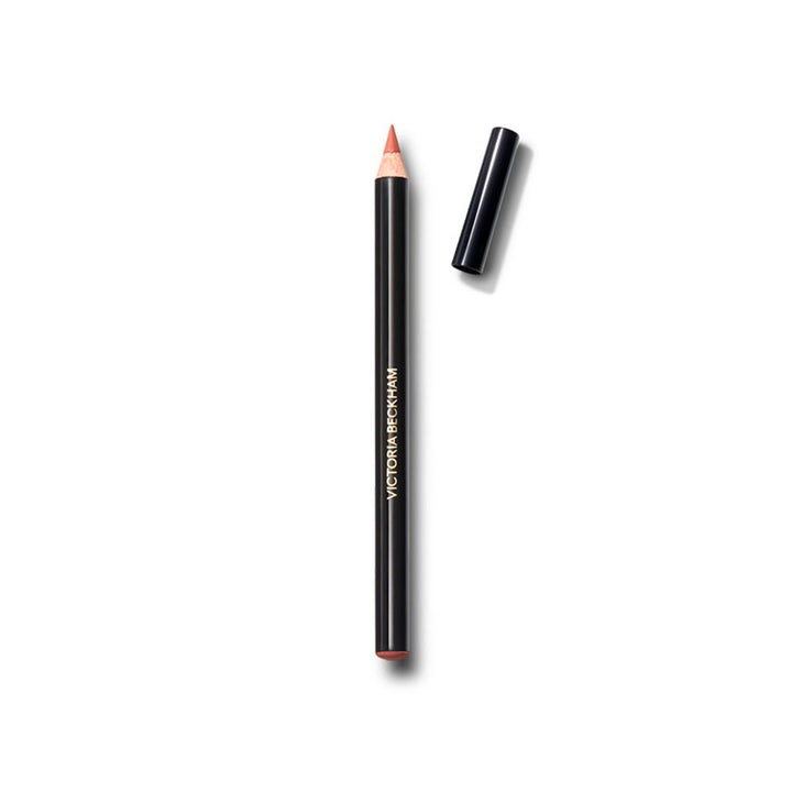 A pale peach colored lip definer pencil with its cap removed, displayed against a white background.
