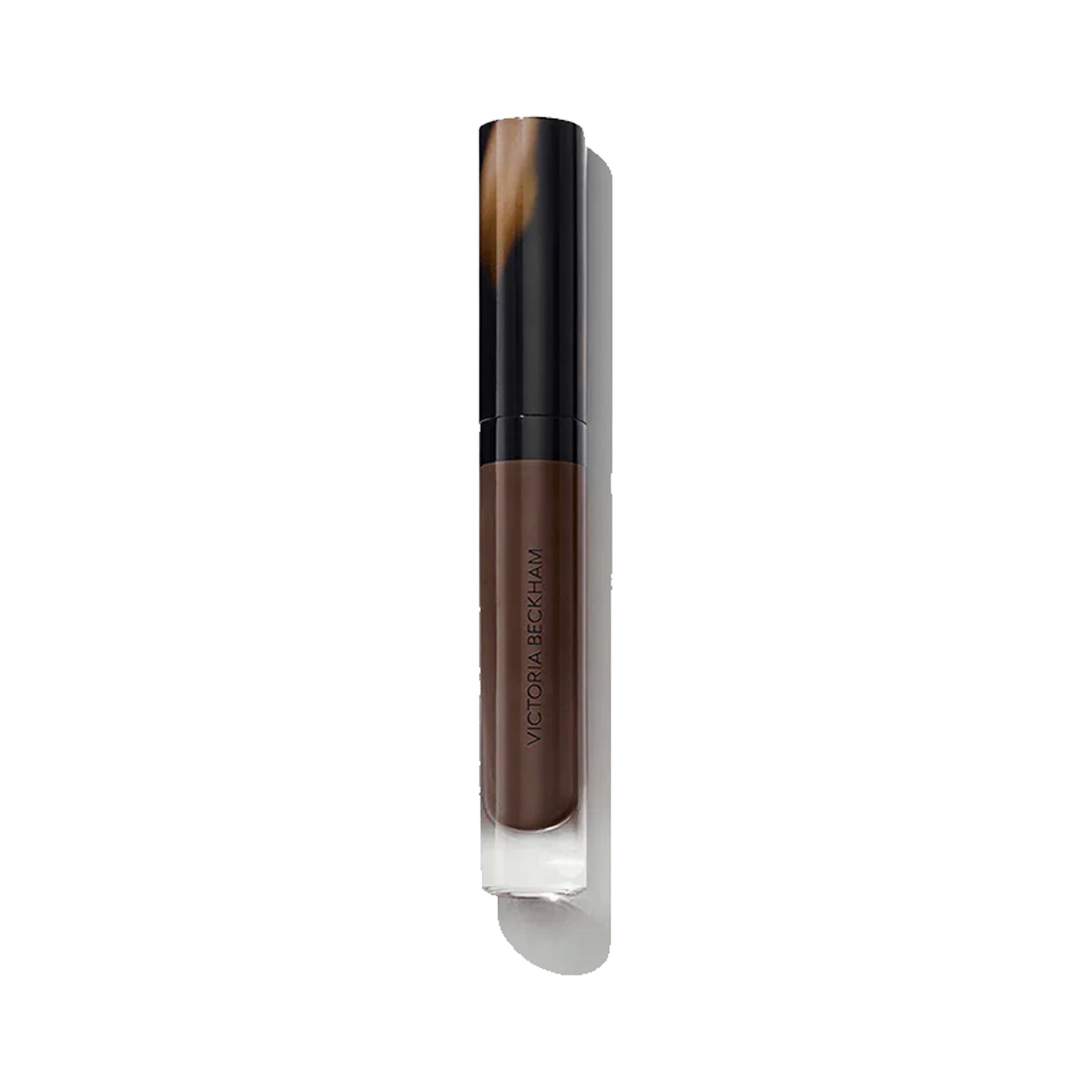 A tube of Victoria Beckham Beauty Posh Gloss in the shade 'Top Down', which is a chocolate berry color.