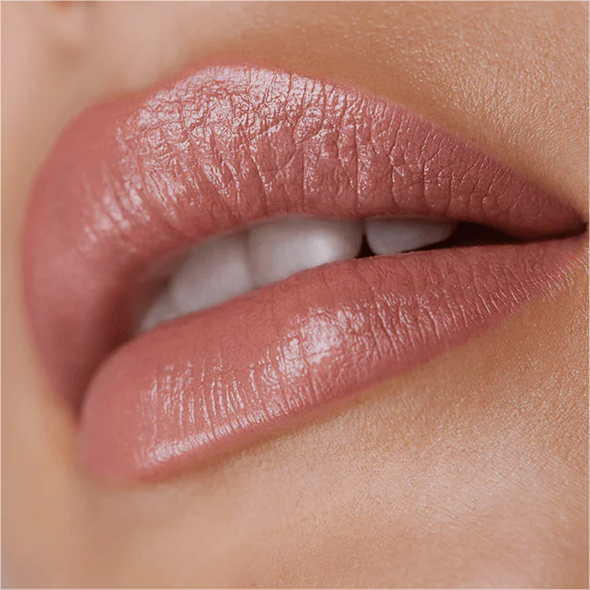 A close up image of lips wearing nude pink lipstick