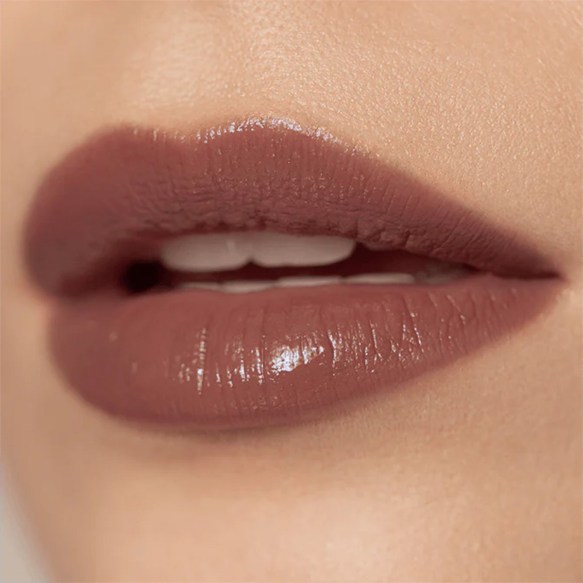 A close up image of lips wearing mauve coloured lipstick