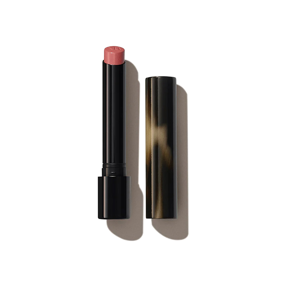 A Victoria Beckham Beauty Posh Lipstick in the shade 'Pout', with the cap removed, showing a coral pink colour.