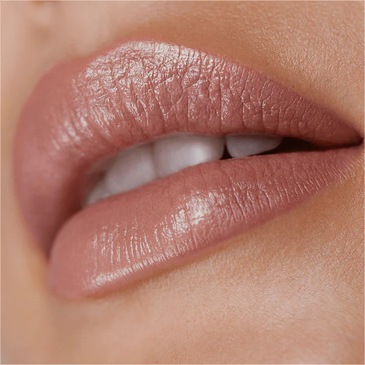 A close up image of lips wearing a pale nude lipstick