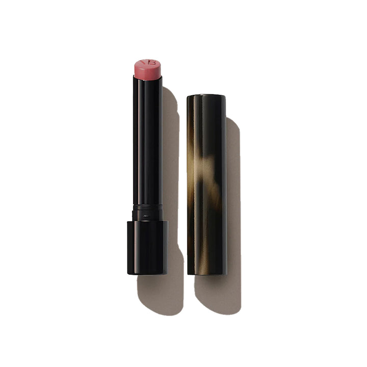 A Victoria Beckham Beauty Posh Lipstick in the shade 'Spark', with the cap removed, showing a mid-tone warm rose color.