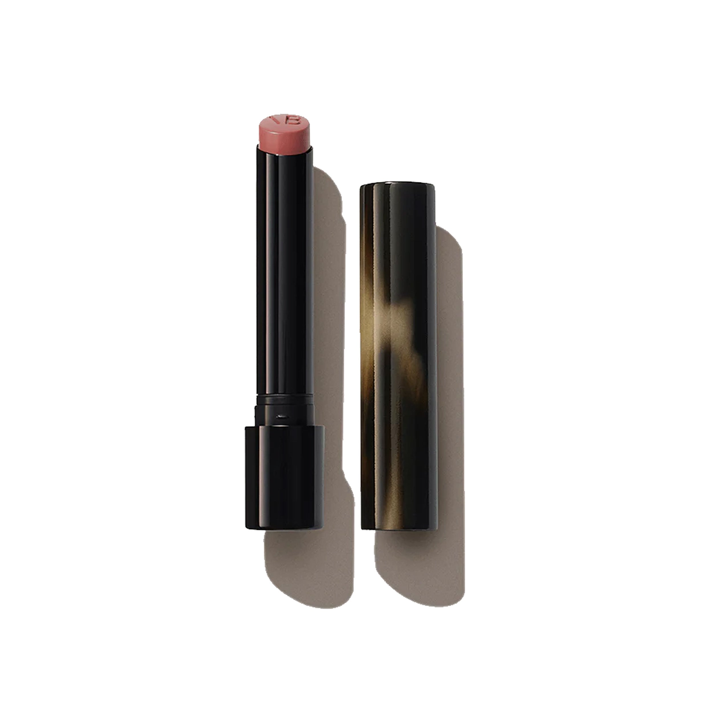 A Victoria Beckham Beauty Posh Lipstick in a neutral pink shade, with the twist-up design cap showing a patterned texture.