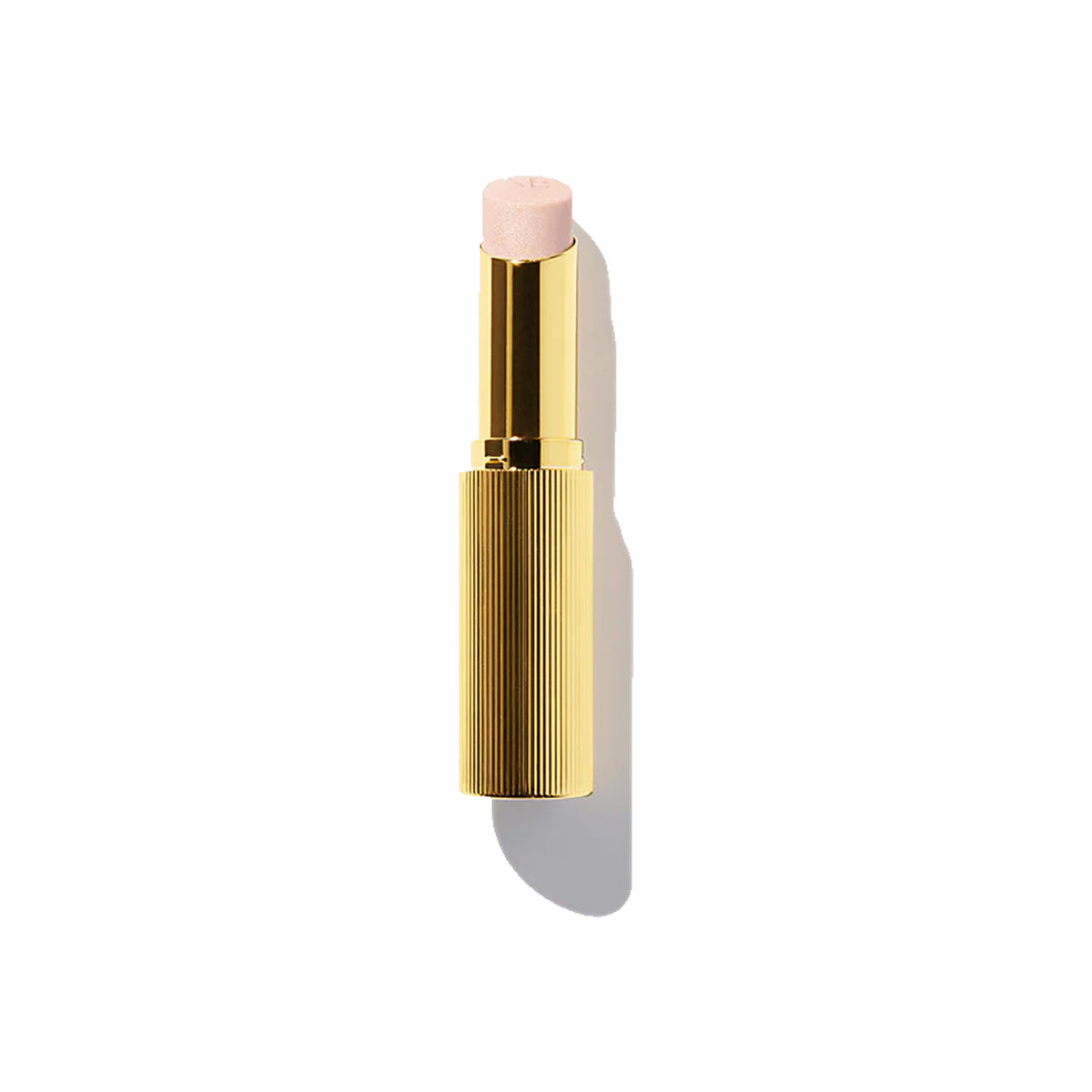 A gold-colored tube of Victoria Beckham Beauty Reflect Highlighter Stick with a pink-colored tip visible at the open end.