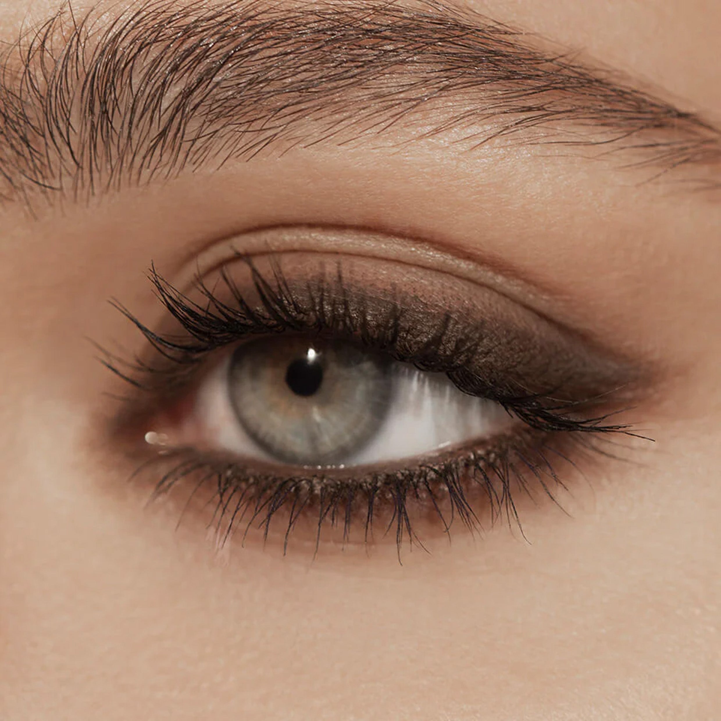 A close up image of an eye with brown eyeliner applied to the eyelid.