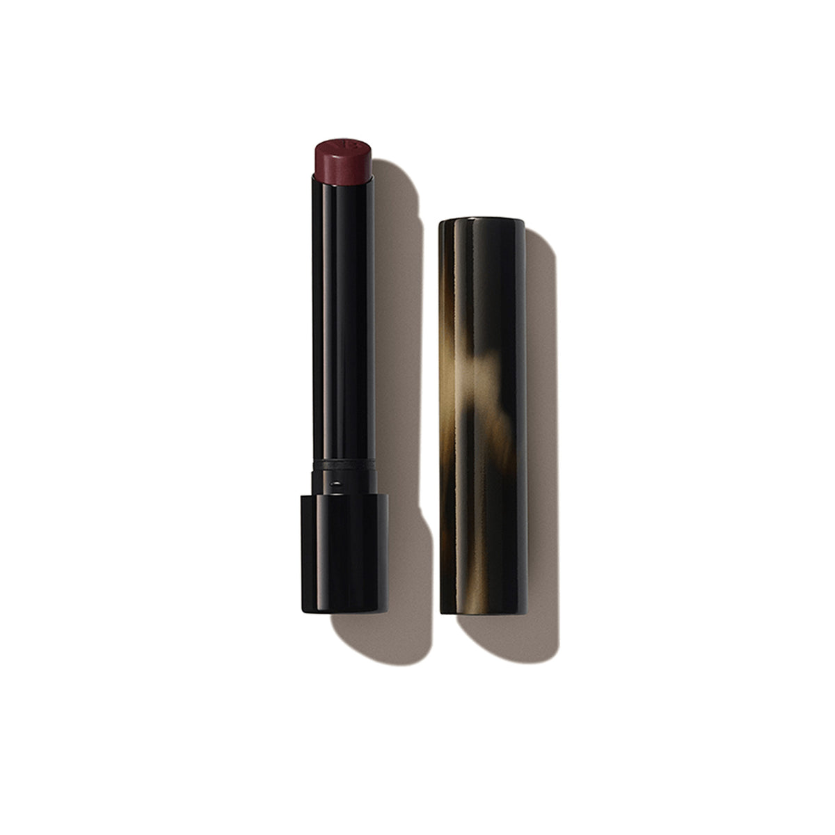 A Victoria Beckham Beauty Posh Lipstick in color 'Play', with the cap removed, revealing a rich plum berry shade.